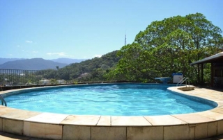 Larga piscina rodeada por jardins luxuriantes
